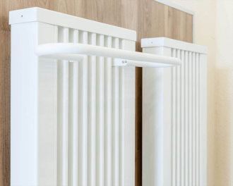 De handdoekdroger kan eenvoudig bovenin tussen de lamellen van een elektrische radiator "gehangen" worden. De bij de radiator meegeleverde afdekking kan teruggeplaatst worden, over de beugels van de handdoekdroger.